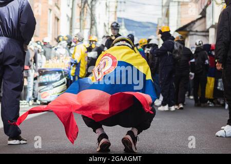 Passo, Colombia. 28 luglio 2021. Un dimostratore con la bandiera colombiana come dimostrazioni si è concluso in scontri notturni tra la polizia in rivolta della Colombia (ESMAD) e i dimostranti, mentre la Colombia segna 3 mesi di proteste anti-governative contro il governo colombiano Ivan Duque, e una nuova riforma fiscale tra disordini e violenze che hanno lasciato almeno 83 morti dall'inizio delle proteste. Il 28 luglio 2021 a Pato-Narino, Colombia. Credit: Long Visual Press/Alamy Live News Foto Stock