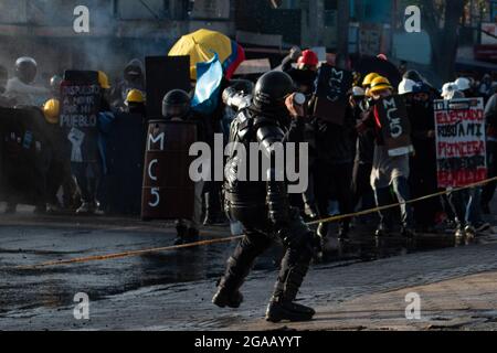 Medellin, Colombia. 28 luglio 2021. Un poliziotto colombiano lancia una granata di gas lacrimogeni ai dimostranti, mentre le manifestazioni si sono concluse in scontri notturni tra la polizia malata colombiana (ESMAD) e i dimostranti, mentre la Colombia segna 3 mesi di proteste anti-governative contro il governo colombiano Ivan Duque, e una nuova riforma fiscale tra disordini e violenza che ha lasciato almeno 83 morti dall’inizio delle proteste. Il 28 luglio 2021 a Medellin - Antioquia, Colombia. Credit: Long Visual Press/Alamy Live News Foto Stock