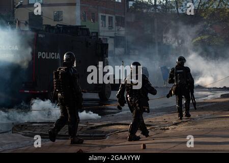 Medellin, Colombia. 28 luglio 2021. I poliziotti in rivolta della Colombia si nascondono dietro un camion corazzato da una rivolta, mentre le manifestazioni si sono concluse in scontri notturni tra la polizia malata della Colombia (ESMAD) e i dimostranti, mentre la Colombia segna 3 mesi di proteste anti-governative contro il governo colombiano Ivan Duque, e una nuova riforma fiscale tra disordini e violenza che ha lasciato almeno 83 morti dall’inizio delle proteste. Il 28 luglio 2021 a Medellin - Antioquia, Colombia. Credit: Long Visual Press/Alamy Live News Foto Stock