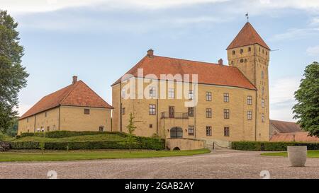 Una strada di ghiaia che conduce ad un grande castello giallo su tre piani con una torre alta, Tosterup, Svezia, 16 luglio 2021 Foto Stock