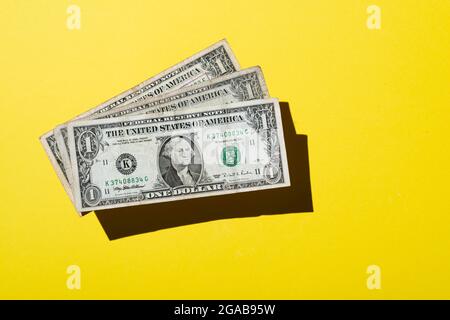 Tre 1 dollaro nota su sfondo giallo Foto Stock