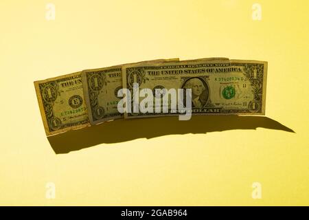 Tre 1 dollaro nota su sfondo giallo, primo piano Foto Stock