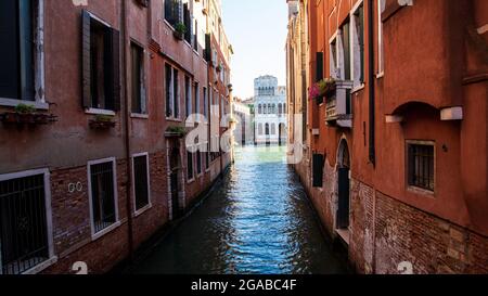 Piccoli canali di mattoni e facciate dipinte con barche a vela Foto Stock