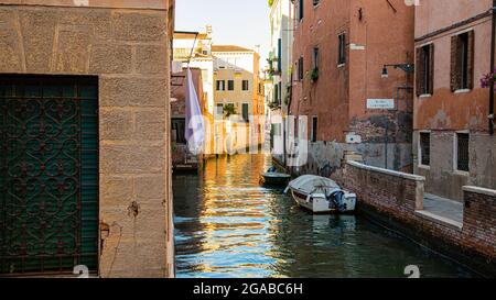 Piccoli canali di mattoni e facciate dipinte con barche a vela Foto Stock