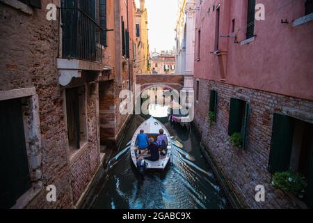 Piccoli canali di mattoni e facciate dipinte con barche a vela Foto Stock