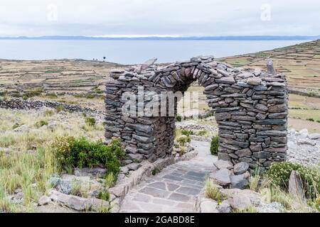 Arco di pietra sulla collina di Pachatata sull'isola di Amantani nel lago Titicaca, Perù Foto Stock