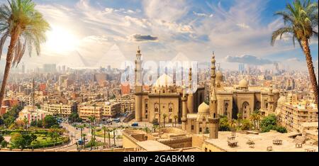 Moschea-Madrasa del Sultano Hassan dietro le palme, il Cairo, Egitto. Foto Stock