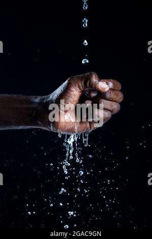 L'uomo africano interagisce con l'acqua. Foto Stock