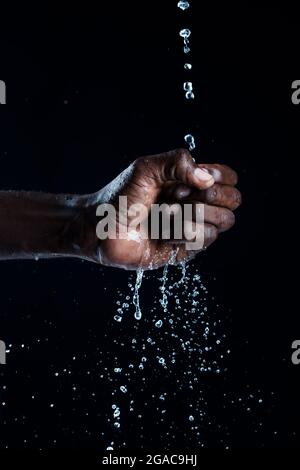 L'uomo africano interagisce con l'acqua. Foto Stock