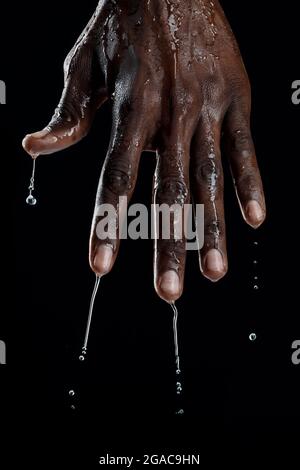 L'uomo africano interagisce con l'acqua. Foto Stock