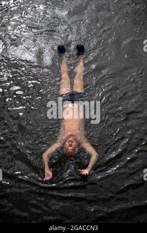 Pechino, Cina. 30 luglio 2021. L'uomo nuota nel fiume Liangma passando per il centro di Pechino, Cina il 30/07/2021 da Wiktor Dabkowski Credit: dpa/Alamy Live News Foto Stock