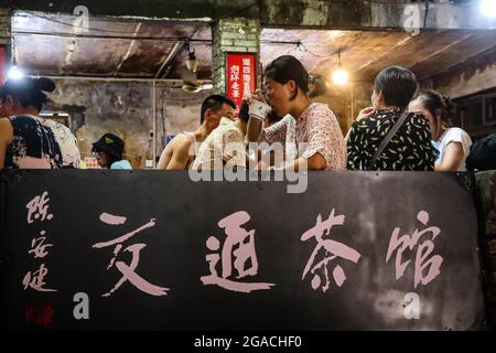 (210730) -- CHONGQING, 30 luglio 2021 (Xinhua) -- la gente chiacchiera mentre beve il tè alla teahhouse di comunicazioni nel Chongqing del sud-ovest della Cina, 26 luglio 2021. Chen Anjian, 62 anni, insegnante di pittura ad olio presso il Sichuan fine Arts Institute, frequenta la Chongqing Communications Teahhouse per più di 20 anni. Fondata nel 1987, la sala da tè Communications è ora l'unica vecchia casa da tè di Chongqing che ha mantenuto lo stile originale degli anni '70 e '80. E' uno dei punti di riferimento culturali chiave di Chongqing, e visitato ogni giorno da migliaia di amanti del tè. "La Teahhouse delle Comunicazioni è la Th Foto Stock