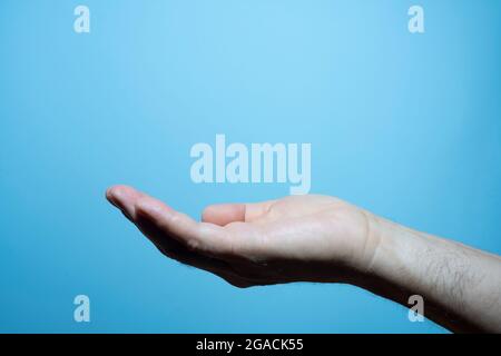 nel palmo della mano di un uomo con sfondo blu Foto Stock