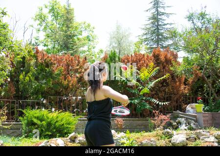 Bambina che gioca a tennis nel suo giardino in una giornata estiva. Focus Girl selettivo Foto Stock