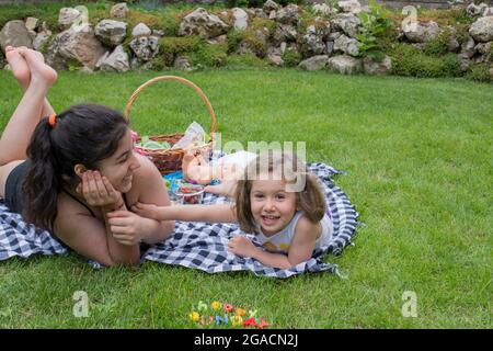 due sorelle che giacciono sull'erba e chiacchierano Foto Stock