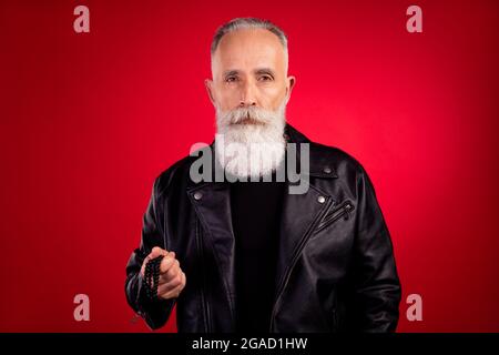 Foto di vecchio bell'uomo serio sicuro concentrato concentrato hipster isolato su sfondo rosso Foto Stock