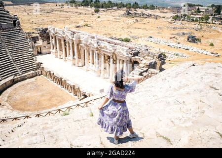 Una giovane donna vestita nell'antica città di Hierapolis. Anfiteatro Hierapolis di 1800 anni. Una donna a Pamukkale. Foto Stock