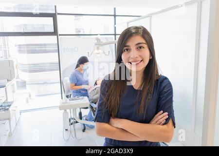 Giovane dentista femminile nel suo ufficio che si occupa di tutti i suoi pazienti in modo professionale. Foto Stock