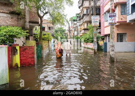 Kolkata, India. 30 luglio 2021. La gente vade attraverso le acque profonde del ginocchio su una strada loggata in Kolkata. (Foto di Sudip Maiti/Pacific Press) Credit: Pacific Press Media Production Corp./Alamy Live News Foto Stock