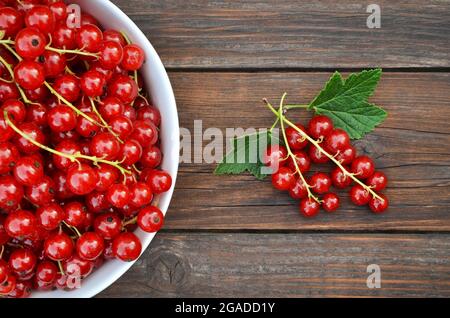 Bacche mature appena raccolte di ribes rosso da vicino su un tavolo di legno. Concetto di alimentazione sana. Foto Stock