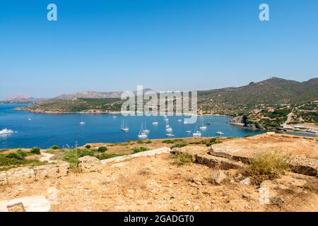 Vista della baia e ancoraggio pieno di barche a vela dal Tempio di Poseidone a Capo Sounion in giornata di sole, Sounion, Grecia. Foto Stock