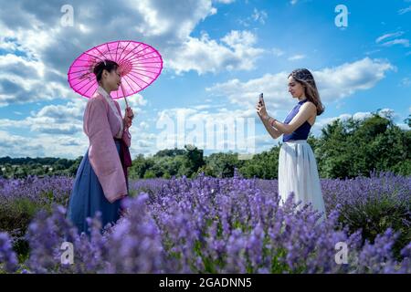 Sutton, Regno Unito. 30 luglio 2021. Regno Unito Meteo: Londra studenti di danza Yuaner e Rebecca godersi il sole alla Mayfield Lavender Farm. Credit: Guy Corbishley/Alamy Live News Foto Stock