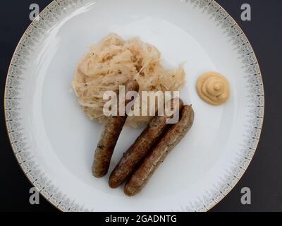 Salsiccia alla griglia di Norimberga o Nürnberger Rostbratwurst con Sauerkraut o cavolo e mostarda acide con vista dall'alto Foto Stock