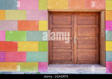 Vecchia porta in legno dipinta marrone vintage e colorati blocchi dipinti sulla parete. Foto di alta qualità Foto Stock