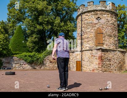 Anziano, anziano o pensionato che gioca a bocce o bocce al sole d'estate, Haddington, East Lothian, Scozia, Regno Unito Foto Stock