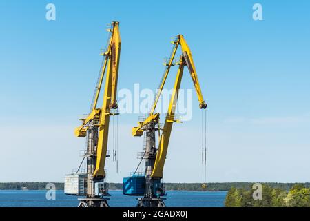 Due autogru per il carico di container di merci su navi e treni Foto Stock