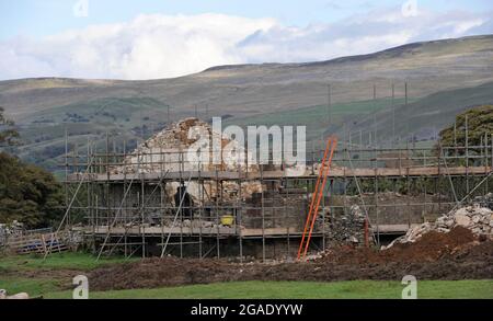 Vecchio fienile di pietra su una fattoria collina che viene tolto e ricostruito come una casa di vacanza, Cumbria, Regno Unito. Foto Stock