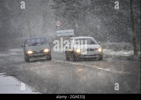 Condizioni di guida invernali pericolose sull'A711 a Kirkcudbright, Dumfries e Galloway, Scozia. Due auto attraversano la neve Foto Stock