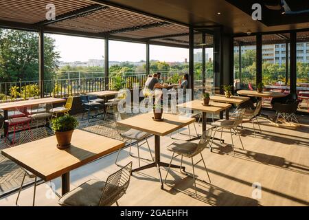 Il ristorante si apre sulla terrazza. Brooklyn House, Pretoria, Sudafrica. Architetto: Boogertman + Partners, 2021. Foto Stock