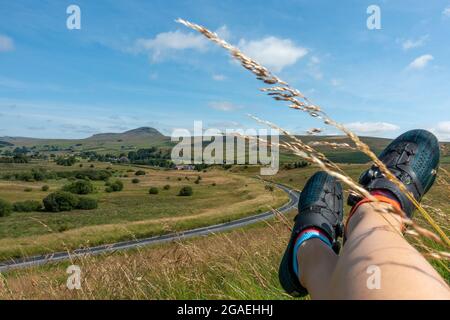 Vista in bicicletta di Pen-y-ghent da Stainforth Lane e Austwick Road in condizioni meteorologiche eccezionali con i piedi dei ciclisti e le scarpe Fizik, Austwick, Yorkshire dal Foto Stock