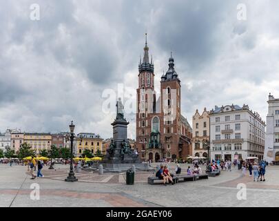 Una foto della piazza principale di Cracovia (Rynek Główny) con la Basilica di Santa Maria e il Monumento Adam Mickiewicz. Foto Stock