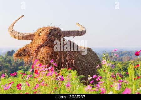 All'interno del giardino fiorito è installato un burattino di paglia a forma di animale, che consente ai visitatori di visitare i bellissimi campi di fiori e i burattini di paglia realizzati con Foto Stock