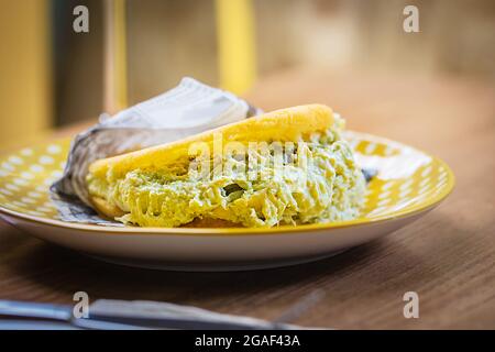 Arepa farcito su un piatto preparato da farina di mais, cucina tradizionale della Colombia e del Venezuela, primo piano Foto Stock