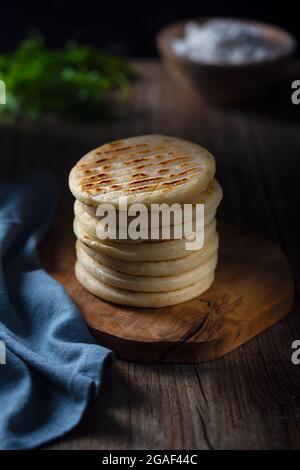 L'arepa è un tipo di pasto preparato con pasta di mais macinata, farina di mais, cibo tradizionale colombiano, stile scuro e moody Foto Stock