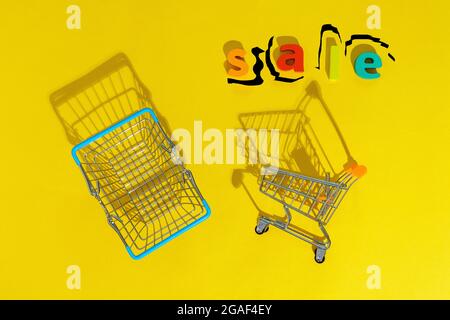 Shopping nel supermercato su sfondo giallo. La vendita iscrizione. Spazio per la copia del testo Foto Stock