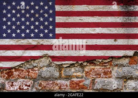 Concetto grafico con una bandiera degli Stati Uniti d'America dipinta su una parete di mattoni danneggiata. Foto Stock