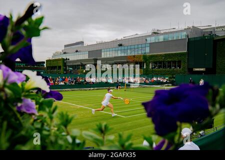 Tamara Zidansek di Solvakia in azione tra i fiori durante la sua partita contro Karolina Pliskova della Repubblica Ceca a Wimbledon Foto Stock