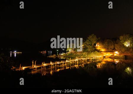 Ponte in legno di bambù con illuminazione splendidamente decorativa in serata, attraversando il fiume Nam Khan a Luang Prabang, Laos. Foto Stock