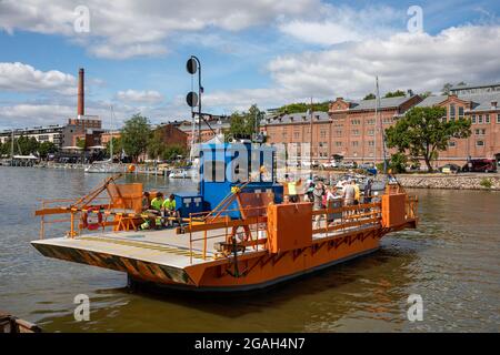 Piccolo traghetto arancione chiamato Föri attraversando il fiume Aura a Turku, Finlandia Foto Stock