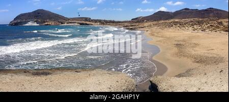 Un kitesurfer che ama il suo hobby sulla spiaggia solitaria chiamata 'Playa de los Genoveses' ad Almeria, Andalusia, Spagna. Concetto di sport acquatici Foto Stock