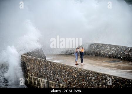 Brighton, 30 luglio 2021: Storm Evert batte la costa di Brighton in alta marea questo pomeriggio, come i visitatori sopportati e goduto il crashin delle onde Foto Stock