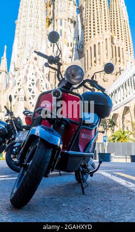 Barcellona, Spagna - 12 aprile 2021 - Vista verticale delle moto scooter di fronte alla Cattedrale della Sagrada Familia Foto Stock