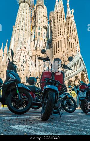 Barcellona, Spagna - 12 aprile 2021 - Vista verticale delle moto scooter di fronte alla Cattedrale della Sagrada Familia Foto Stock