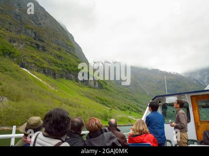 Naeroyfjord, Gudvangen, Norvegia - 5 maggio 2017: I turisti godono di una splendida vista panoramica sulle montagne circostanti e sul paesaggio, mentre cruisin Foto Stock