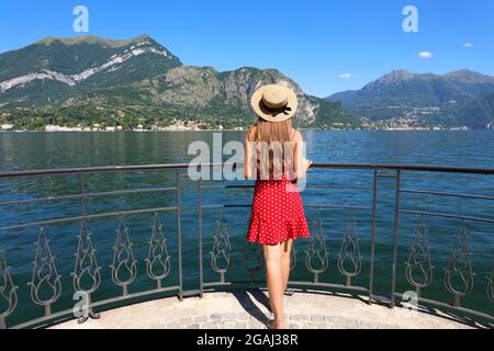 Vacanze sul Lago di Como. Vista posteriore di bella ragazza di moda godendo di vista sul Lago di Como dal Bellagio Promenade. Vacanze estive in Italia. Foto Stock