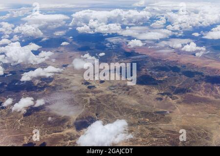 Vista aerea del paesaggio delle montagne del deserto del New Mexico nelle nuvole soffici dall'aereo alla finestra Foto Stock